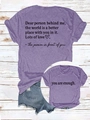 Detail of purple short sleeve t-shirt featuring double-sided motivational print on wood floor - Purple (Black Text)
