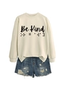 Detail view of Be Kind slogan and braille dot print on cozy cream-colored crewneck sweatshirt - Sand (Black Font)