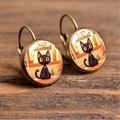 Detailed close-up of bronze-finish Halloween earrings with black cat and text on wood - Black Cat & Jack-o'-lantern (Style 5)