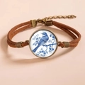 Detail of vintage bronze hummingbird bracelet with blue bird glass pendant and brown cord - Blue and White Bird Style 1 (款式1)