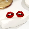 Pop-art vergulde rode lippen emaille oorknopjes set gepresenteerd op witte stenen - Rode Lippen Oorbellen