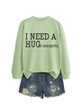 Detail of light green crewneck sweatshirt with margarita slogan and ripped denim shorts - S / Black Font / Olive Green
