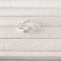 Adjustable silver leaf pattern ring on a beige textured jewelry display tray - Bowknot Style