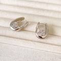 Silver conch-shaped U-shaped hoop earrings with matte spiral texture in jewelry tray - Silver