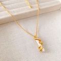 Franse vintage barokke parelketting met gouden spiraalhanger op een crème sieradendoosje - Ketting