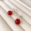 Minimalistische rote Achat-Ohrhänger mit polierten Silbersteckern auf Schmuckschatulle - Roter Achat-Stil / Rot