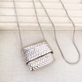 Silver woven bag pendant necklace with a fine snake chain on a jewelry display box - Silver