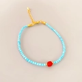 Detailed shot of blue beaded bracelet with red gemstone and gold adjustable lobster clasp - Red Agate