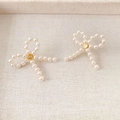 Elegante perlenohrstecker in schleifenform mit zirkonia auf einem beigen tablett - Lange Schleife Ohrstecker