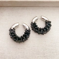 Detailed view of C-shaped hoop earrings featuring silver metal and black beaded texture - Black