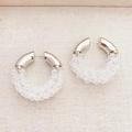 Handmade crystal beaded silver hoop earrings for women on beige fabric background - White