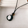Pendentif galet noir moderne avec perle œil de tigre sur cordon noir minimaliste - Collier