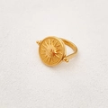 Rotating golden spinner ring with embossed sun and evil eye design on white background - Gold
