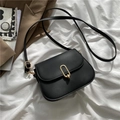 Minimalistische schwarze Satteltasche mit goldener Metallschnalle und matter Ledertextur - Schwarz