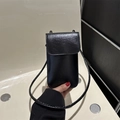 Vertical black glossy leather mini phone bag with shoulder strap shown in hand - Black
