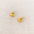 Gros plan de boucles d'oreilles dorées en forme de croissant sur lin beige - Doré
