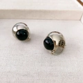 Pendientes de plata con hemisferios de ónix negro sobre fondo de tela texturizada - Negro
