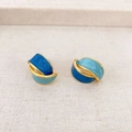 Franse vintage blauwe emaille oorbellen met gouden rand op beige stoffen ondergrond - Blauw