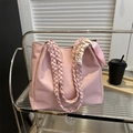 Borsa tote rosa con manici intrecciati e dettaglio foulard di seta su un carrello - Rosa