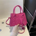 Fuchsia trapezium handtas met klaverreliëf en bijpassende envelop-tas accessoire - Roze