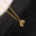 Elegante goldene Lotus-Halskette mit poliertem Perlenanhänger auf schwarzem Hintergrund - Lotus Samen Kapsel Halskette - Gold