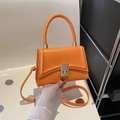 Elegant orange square handbag in matte faux leather with woven handle and metal twist lock - Orange
