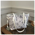 Detalle del bolso tote blanco con estampados de mariposas púrpuras y cierres metálicos dorados - Plateado
