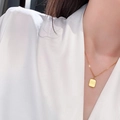 Detailansicht einer goldenen quadratischen Kette mit Gravur where is love? am Model - Gold