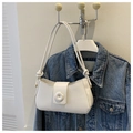 Dettaglio di una borsa sottobraccio bianca minimalista con nodi decorativi e finiture oro - Bianco