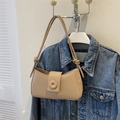 Detail of beige minimalist baguette bag with knot strap and circular decorative buckle - Khaki