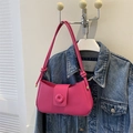 Detail of bright pink leather shoulder bag featuring knotted strap and round buckle accent - Rose Red