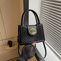 Klassieke zwarte geplooide crossbodytas met een gouden hartlogo en elegante handvatten - Zwart