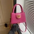 Magenta crossbodytas met concentrisch boogpatroon en gouden hartlogo in de hand mode - rozenroze