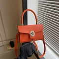 Borsa arancione in pelle martellata con manico intrecciato e chiusura a girello al sole - Arancione