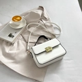 White minimalist square crossbody handbag with gold clasp and black handle detail - White
