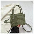Detalle de textura de cocodrilo verde en bolso tote elegante con herrajes de plata - Verde