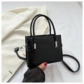 Detalle de bolso negro con textura de cocodrilo y herrajes de metal plateado - Negro