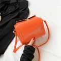 Sac bandoulière orange vif à texture ondulée et fermoir doré sur fond contrasté - Orange