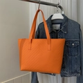 Detail of orange tote bag with V-shaped quilting and long shoulder straps displayed - Orange Inverted Chevron