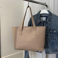 Dettaglio della borsa tote beige con cuciture a V eleganti su texture in pelle opaca - Khaki Chevron Invertito