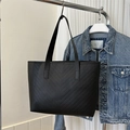 Macro view of minimalist black tote bag featuring classic V-shaped chevron quilted stitching - Black Upright Chevron