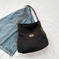 Large black canvas tote bag with brown leather straps and patch for casual style - Black