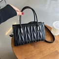 Black quilted top handle handbag with wavy stitching and detachable crossbody strap - Black