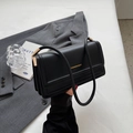 Minimalist black leather shoulder bag with gold metal trim and chic fashion lettering - Black