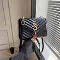 Borsa a tracolla nera trapuntata con motivo a V dorato e nappa metallica chic - Nero