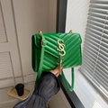 Borsa a tracolla verde con trapuntatura a V, logo dorato e nappa decorativa con frange - Verde