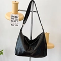 Minimalistische schwarze Hobo-Schultertasche mit Faltenstruktur und breitem Riemen - Schwarz