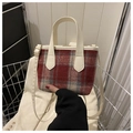 Details der rot-grau karierten Wollhandtasche mit cremefarbenem Lederriemen und Goldschnalle - Rot