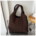 Detail of dark brown popcorn fabric bag with bubble texture on a modern metal surface - Brown
