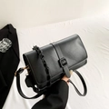 Bolso bandolera negro chic con asa trenzada y detalles dorados sobre tela blanca - Negro